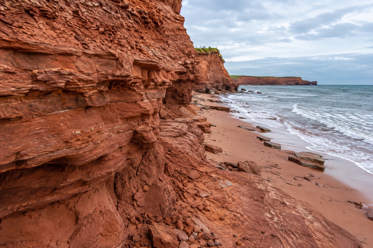 Close-up of iron-red sandstone cliff and red sand beach on Prince Edward Island